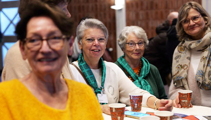 Vier Frauen stehen um einen festlich geschmückten Tisch mit Getränkebechern und blicken in die Kamera bei der Weihnachtsfeier 2025 von Amalie Sieveking Krankenhaus, Residenz am Wiesenkamp, Feierabendhaus Volksdorf und Albertinen Kindertagesstätte Volksdorf auf dem Gesundheitscampus Volksdorf in Hamburg