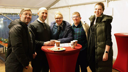 Fünf Gäste blicken an einem Tisch mit Getränkebechern im Festzelt in die Kamera bei der Weihnachtsfeier 2025 von Amalie Sieveking Krankenhaus, Residenz am Wiesenkamp, Feierabendhaus Volksdorf und Albertinen Kindertagesstätte Volksdorf auf dem Gesundheitscampus Volksdorf in Hamburg