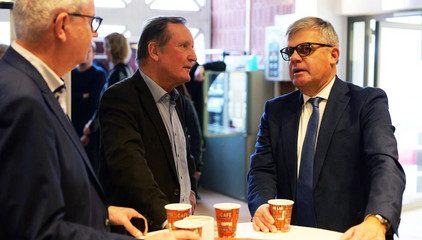 Matthias Scheller unterhält sich mit Gästen an einem Tisch mit Kaffee- und Glühweinbechern bei der Weihnachtsfeier 2025 von Amalie Sieveking Krankenhaus, Residenz am Wiesenkamp, Feierabendhaus Volksdorf und Albertinen Kindertagesstätte Volksdorf auf dem Gesundheitscampus Volksdorf in Hamburg