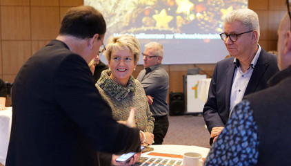 Sabine Pfeifer von der Stiftung Zukunft Amalie unterhält sich an einem Tisch mit Gästen bei der Weihnachtsfeier 2025 von Amalie Sieveking Krankenhaus, Residenz am Wiesenkamp, Feierabendhaus Volksdorf und Albertinen Kindertagesstätte Volksdorf auf dem Gesundheitscampus Volksdorf in Hamburg